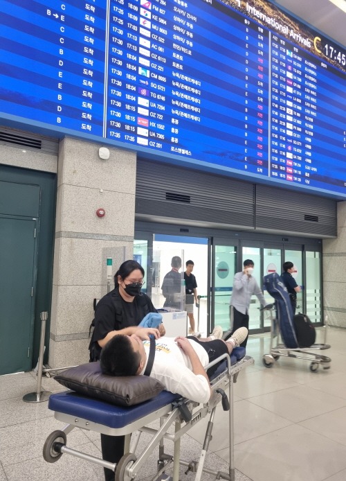 복지정책과-25일 환자이송침대에 실려 인천국제공항 입국장에 들어서는 백씨 모습.jpg